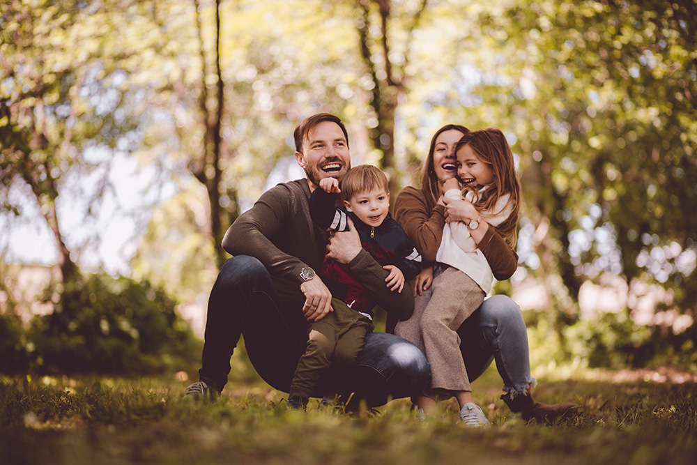 Four family members hugging outside in nature